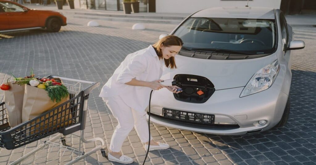 Lady charging ev car at shopping complex